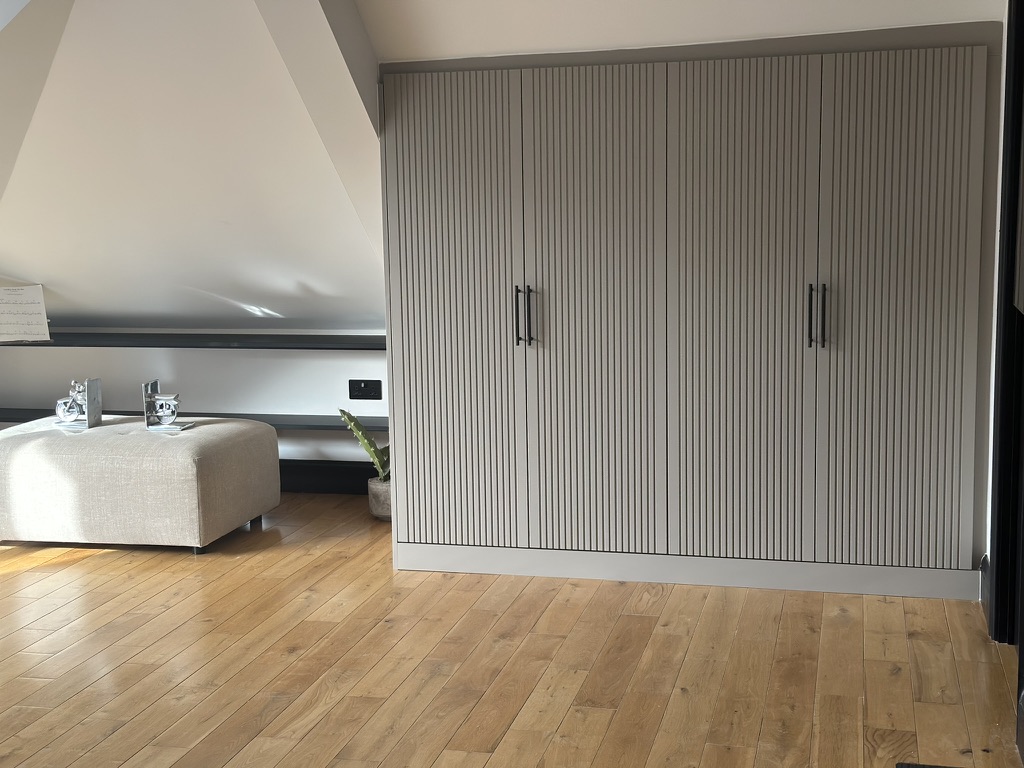 Completed loft room with fitted wardrobes and storage